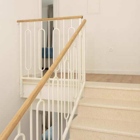 Staircase with white railing and oak handrail